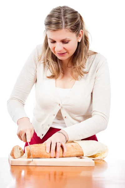 Glad ung kvinna skära färskt bröd — Stockfoto