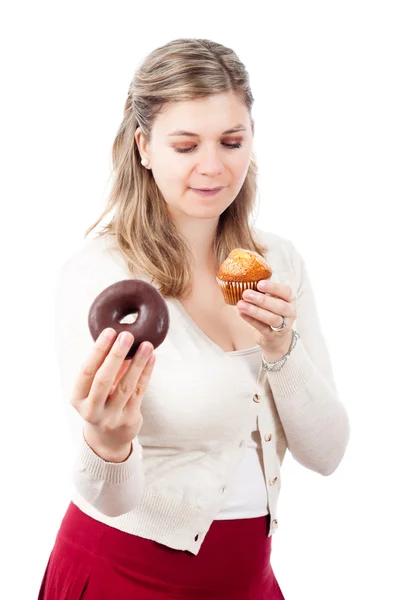 Hungry woman holding sweet muffin and donut — Stock Photo, Image