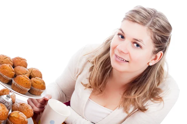 Happy woman with cup of tea and muffins — Stock Photo, Image