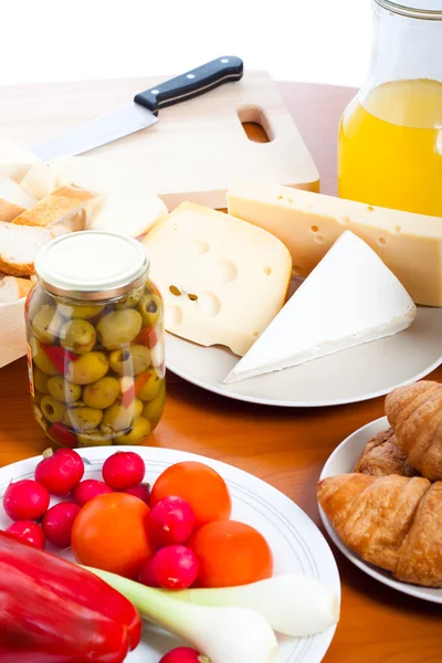 Tabell med ost, oliver, grönsaker och kniv — Stockfoto