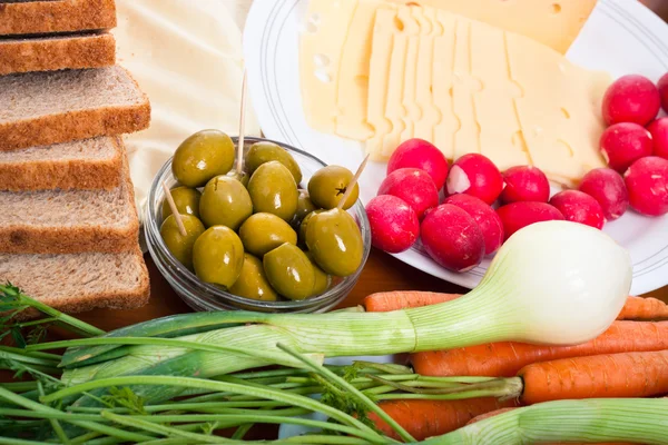 Produtos hortícolas frescos, azeitonas, queijo e pão — Fotografia de Stock
