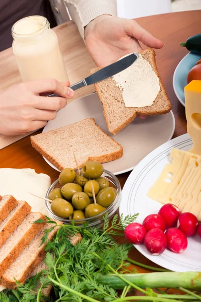 Verspreiding van mayonaise op broodjes — Stockfoto