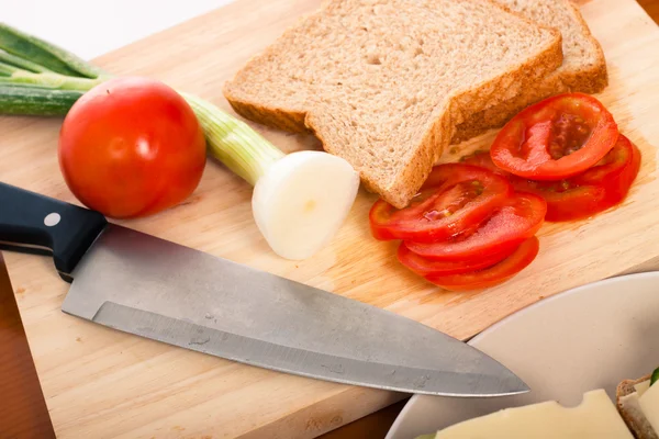 Snijplank met mes, brood en fruit — Stockfoto