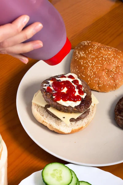 Derramando ketchup em hambúrguer caseiro — Fotografia de Stock