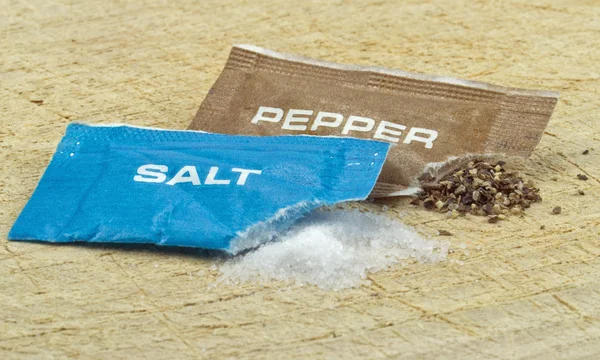 Открытые пакетики с солью и перцем — стоковое фото