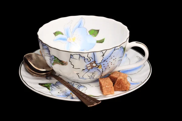 Taza de té, una cucharadita de azúcar en un platillo — Foto de Stock