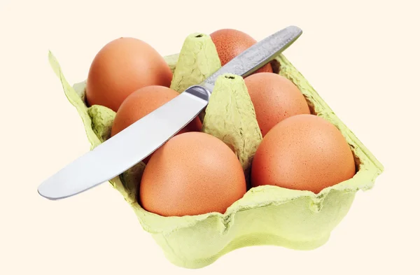 Os ovos na embalagem. Faca de metal — Fotografia de Stock