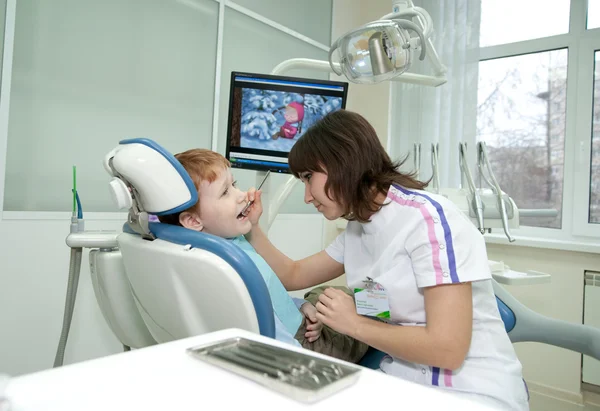 O stomatologist examina dentes do pequeno rapaz . — Fotografia de Stock
