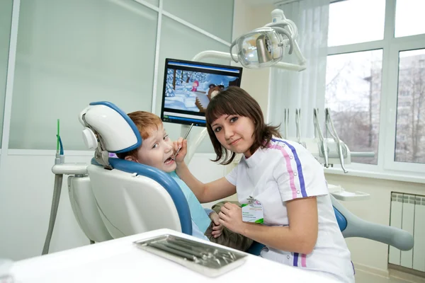 O stomatologist examina dentes do pequeno rapaz . — Fotografia de Stock
