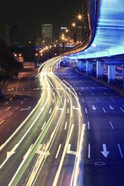 Circular viaduct road rainbow light trails night scene clipart