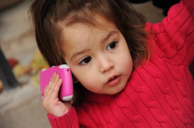 Little girl with a cell phone clipart