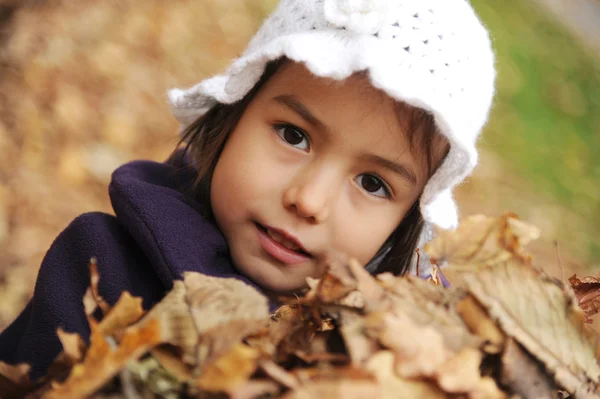 Een meisje die spelen met de bladeren — Stockfoto