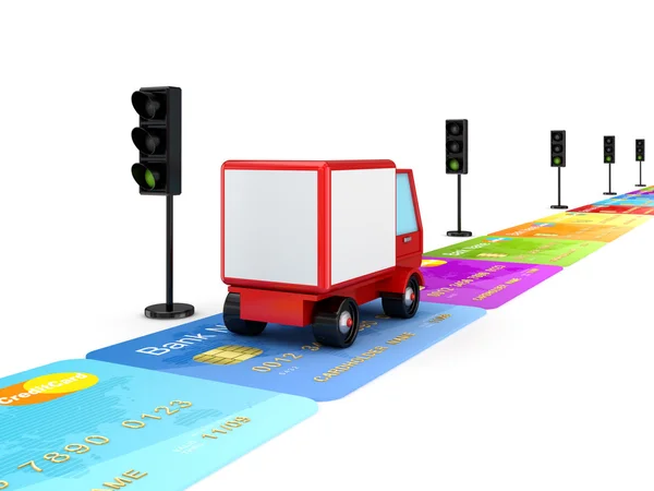 Красный грузовик едет по дороге, сделанной из красочных кредитных карт . — стоковое фото
