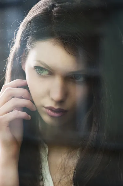 La mujer pensante en la ventana presentada en primer plano — Foto de Stock
