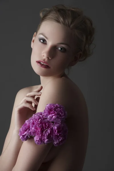 Lage belangrijke meisje met paarse carnation bloem — Stockfoto