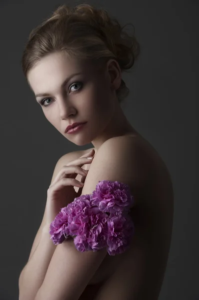 Elegant flicka stående med lila nejlika blomma — Stockfoto
