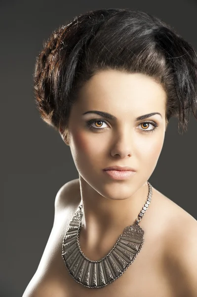 La fille avec un collier en argent, elle regarde dans la lentille — Photo