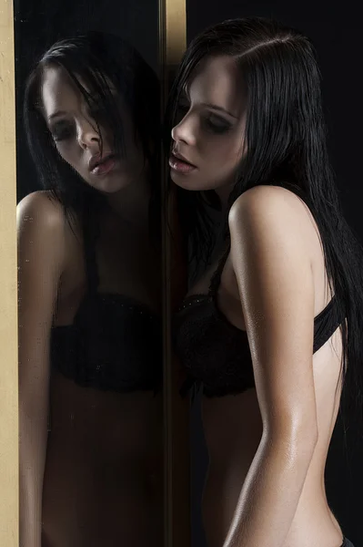 Mulher sexy em roupa interior ao lado de um espelho — Fotografia de Stock