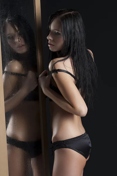 Sexy woman next to a wet mirror — Stok fotoğraf