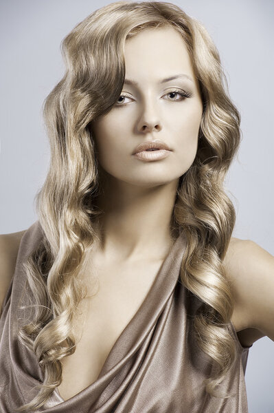 Very beautiful and attractive young blond lady in elegant silk dress and with old fashion hair style