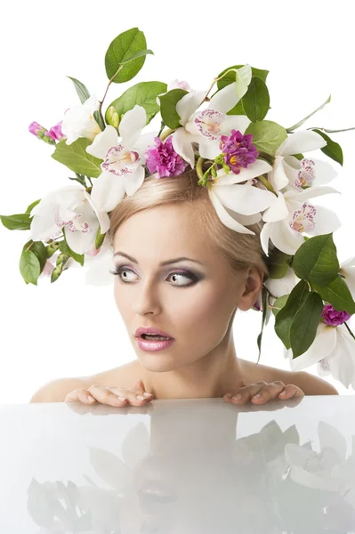 Bonita rubia con corona de flores en la cabeza, su cara está vuelta de th — Foto de Stock
