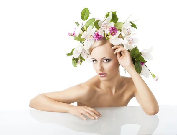 Biondo grazioso con la corona del fiore sulla testa, guarda dentro alla arguzia della lente — Foto Stock