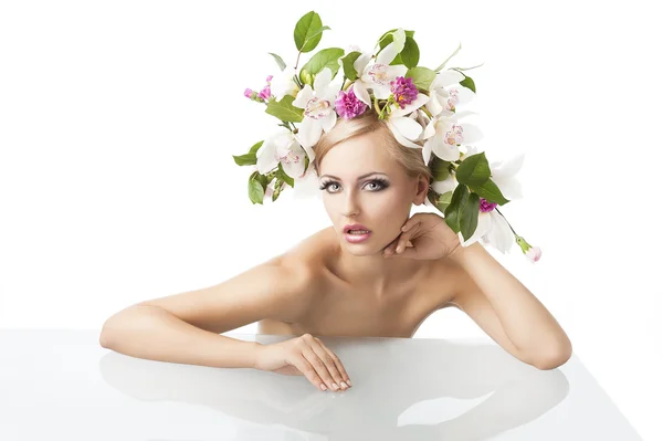 Söt blond med blomma krona på huvudet, hon ser i linsen — Stockfoto