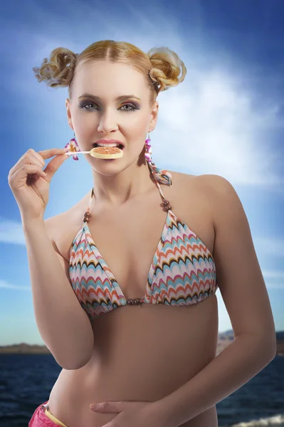 Blond meisje eten snoep — Stockfoto