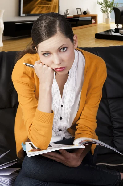 La fille qui lit un livre, son visage repose sur son poing droit — Photo