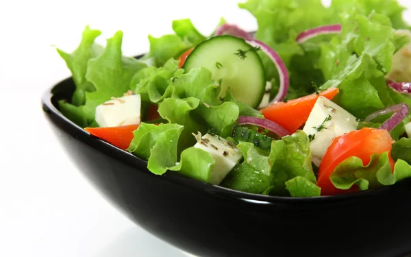 Греческий салат в черной тарелке — стоковое фото
