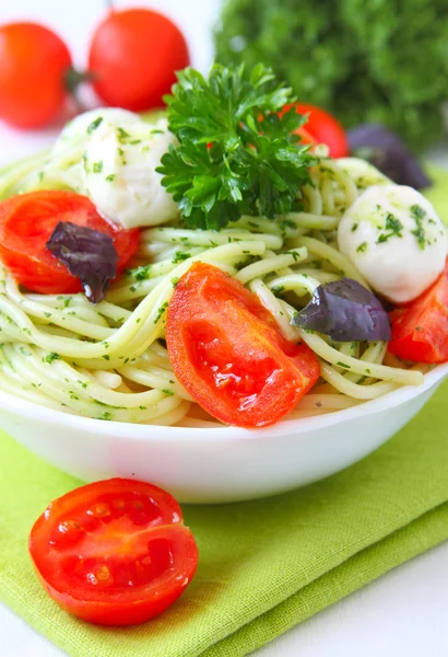Спагетти с соусом песто, помидорами черри и сыром — стоковое фото