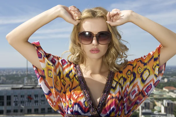 Hermosa chica en gafas de sol en el fondo cielo azul — Foto de Stock