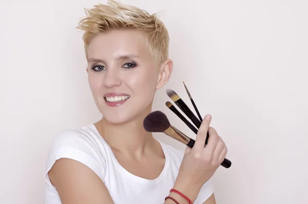 Maquillaje artista sosteniendo cepillos — Foto de Stock
