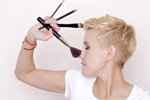 Maquiagem artista segurando escovas — Fotografia de Stock