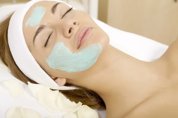 Jeune femme obtenir beauté masque de peau traitement sur son visage avec — Photo