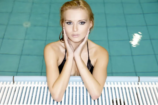 Mooie jonge vrouw permanent in een zwembad — Stockfoto
