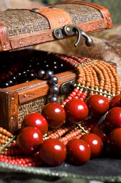 Close-up old jewelery chest with necklaces placed on scarves Stock Image