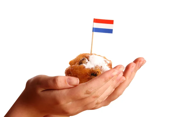 Duas mãos jovens oferecendo um típico donut holandês — Fotografia de Stock
