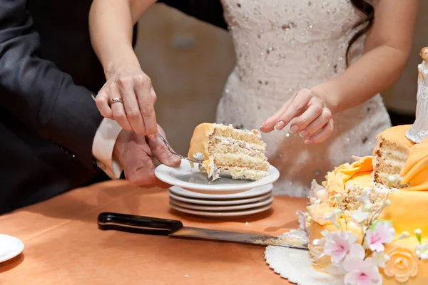 Der Bräutigam und die Braut teilen sich einen Kuchen — Stockfoto