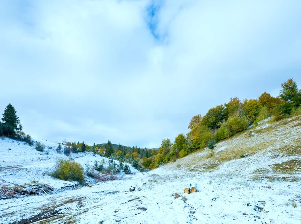 First winter snow on autumn mountain dirty road — Stock Photo, Image