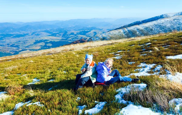 Les enfants se reposent sur le plateau de montagne d'automne avec la première neige d'hiver — Photo