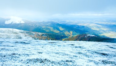 First winter snow on autumn mountain plateau clipart