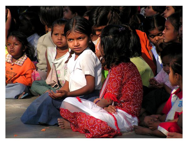 Pretty girl from India watching performances of students in school,