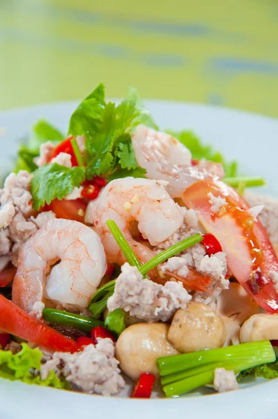 Thailändisch gekleideter würziger Salat mit Garnelen, Schweinefleisch, grünen Kräutern und Nüssen: köstlich — Stockfoto