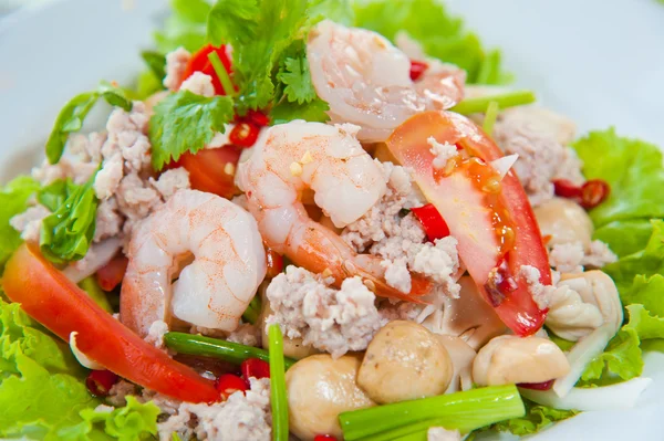 Thailändisch gekleideter würziger Salat mit Garnelen, Schweinefleisch, grünen Kräutern und Nüssen: köstlich — Stockfoto