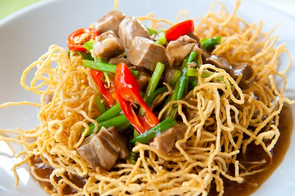 Chinese style deep fried yellow noodles with pork, chili, vegetables and so — Stock Photo, Image