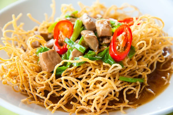 Chinese style deep fried yellow noodles with pork, chili, vegetables and so — Stock Photo, Image