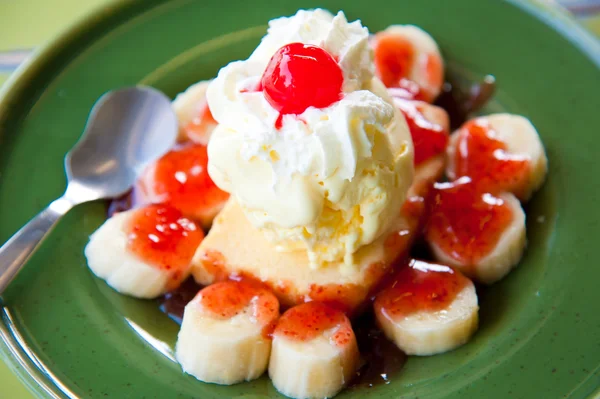 One scoop of vanilla ice-cream topping with banana, cream, red jelly and st — Stock Photo, Image