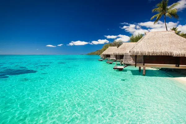 Villas op de tropisch strand met stappen in water — Stockfoto