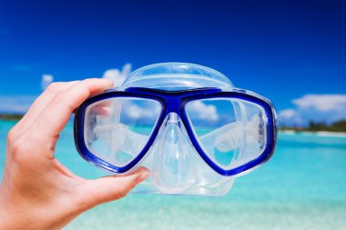 Snorkel googles against beach and sky clipart